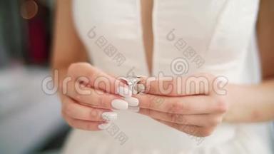 女手用银色金戒指钻石架聚焦.. 女人戴着订婚戒指，手指打磨指甲